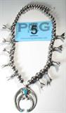 Jewelry Silver Squash Blossom Turq. Naja Necklace
Wonderful silver squash blossom necklace featuring a silver Naja symbol pendant with inlaid turquoise, naturally occurring light brown characteristics throughout, with silver balls / beads, smaller at the hook clasp, graduating in size to the center of the necklace. Unsigned, confirmed as silver by consignor. Measures 22.75" long.
Total weight: 3.57 ozt