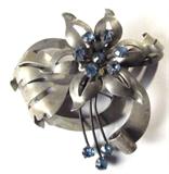 Jewelry Sterling Floral Brooch w/ Blue Stones
Wonderful sterling silver brooch. A six point flower with ten pale blue stones, possibly Garnet, arranged in the center of the flower as well as at the bottom of three sterling silver rods for embellishment. Surrounded by leaf style designs, marked / signed "Sterling". Measures 2.75" x 2".
Total weight: 0.64 ozt