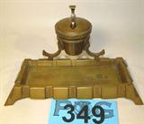 Vintage Brass Inkwell w/ Glass Insert
A vintage inkwell which appears to be brass. Has a hinged lid with small glass insert to hold the ink. The lower platform holds the pen when not in use. Measures 7.5" wide and 4.5" tall.