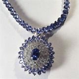 Jewelry 14kt Gold Tanzanite & Diamond Necklace
Exquisite 14kt white gold necklace featuring Tanzanite and diamond stones. Included AIG Pre-Sale Estimated Retail & Gemological Report reads: "One electronically tested 14kt white gold ladies cast & assembled Tanzanite and diamond necklace with a bright polish finish. Seventeen and one-half necklace features a cascading Tanzanite and diamond pendant, supported by a flexible ribbon of Tanzanite terminating in a concealed clasp with safety. Identified with markings of "K14". Condition is new, good workmanship. Containing:
One prong set oval mixed cut natural Tanzanite, approximate weight of 2.23ct., clarity is eye clean, type I, medium, very slightly grayish, blue color, (GIA B 5/3) to medium, very slightly grayish, purple, (GIA P5/3), cut is good. Transmitting light with no distortion. Graded in the setting.
Numerous prong set oval mixed cut natural Tanzanite approximate total weight of 42.73ct., clarity is eye clean, type I, medium, very