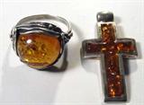 Jewelry Lot of 2 Sterling & Amber Pendant & Ring
Lot of 2 Amber & sterling silver pieces:
- Lovely amber cross pendant framed in smooth sterling silver on the front and textured on the back side, marked / signed with an unidentified signature.
- Beautiful sterling silver & amber ladies ring featuring a round / cushion cut amber stone accentuated by unique silver design with antique style staining. Stone is slightly cracked. Size 9.5.
Total weight: 0.29 ozt