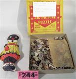 Lot of 2 Vintage Toys Black Vinyl Doll & Puzzle
A wonderful lot filled with two items that bring memories of yesteryear. Great lot for collectors! Lot includes:
- A Black Americana Aunt Jemima stuffed vinyl doll. The name "Diana" is printed on the back of the doll. No other manufacturer marks are found. The doll is in good condition with no cracks in the vinyl. There is one small hole in the outer seam near the doll's dress bottom. She measures 9" long.
- A 250 piece jigsaw puzzle, "End of Day". This Five Star Puzzle was produced by Whitman Publishing Co. The box has string around it with a not on top that states "This puzzle has all the pieces." The box was not opened to verify that statement. Completed puzzle measures 12.5" x 15.5" according to box.