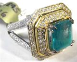 Jewelry 18kt Two Toned Gold Emerald & Diamond Ring
Fantastic 18kt yellow and white gold ring featuring large a large prong set emerald stone and small diamond stones, size: 6.75. Included AIG Pre-Sale estimated retail and Gemological report reads: "One electronically tested 18kt two-tone, white & yellow gold ladies cast and assembled emerald and diamond ring. Condition is new, good workmanship. Featuring an emerald set within a two-tiered yellow gold diamond bezel, supported by a white gold diamond set, elaborate under gallery and diamond set split shoulders, completed by a four millimeter wide band. Bright polish finish with milgrain detailing. Identified with markings of "18k". Containing:
One prong set rectangular step cut natural emerald, measuring 9.10 x 8.20 x 6.50mm, approximate weight of 3.19ct. Clarity is heavily included, type III, medium, moderately strong, very slightly bluish green color, (GIA vslbG 5/4), cut is good. Transmitting light somewhat diffusely, transparent to t