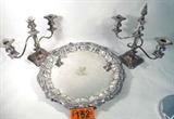 Mixed Lot Silver Plate Tray & Candelabra
Add a touch of elegance to your next dinner party with these beautiful silver plated items:
- Two identical candelabra / candlesticks. Ornately carved / molded bases with three candle stem holders. Bases have a manufacturer mark. Each of these measure approximately 9" tall an 12" wide. A matching candle snuffer is included.
- A Deo-Dante round silverplate serving tray. This large 17" diameter tray has beautiful carved / molded edges. The center features a grand lion design.