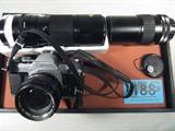Canon AE-1 35mm Camera w/ Extra Lens
This lot features a Canon AE-1 35mm camera with neck strap and the following lens:
- Canon 50mm
- Makinon 200mm
- Canon 200mm zoon lens
Z14