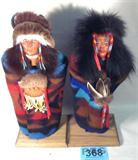 Art Lot of 2 Native American Indian Figurines
A pair of Native American Indian figurines which appear to be hand crafted. The man and woman stick figurines are similarly dressed in wool blankets, with fur and leather trim. Both figurines have beaded decorations. The woman figurine is signed on the bottom "Velvet Norton" and has a paper label which reads G-28 (Blue Woman). The male figurine has a paper label which reads "G-29". Each figurine measures 16" tall and stand on a 5.5" x 7" wooden base.