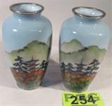 Lot of 2 Oreintal Style Porcelain Vases
This lot includes two pretty porcelain vases featuring similar Oriental landscape scenes which include a Pagoda. Both vases have a metal ring on the base and on the rim. One vase has chips in the glass near the top rim and a stress crack near the middle. The other vase is free of chips and cracks. Each vase measures 7" tall.