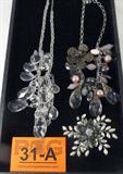 Jewelry Lot of 3 Beaded Costume Necklaces & Brooch
Lot of 3 fabulous costume jewelry pieces:
- Magnificent floral brooch featuring several smoky gray colored rhinestone / pastes arranged in the shape of a flower, surrounding a large iridescent faceted rhinestone / paste. Many faux pearl stones arranged in a vine style design branching out from all angles behind the flower, a stunning addition to any jewelry collection. Standard bar pin clasp in the back, measures 4" x 3.25" (estimated).
- Marvelous silver colored necklace featuring many clear faceted stones, pear shaped, dripping across the neckline with several draping silver colored chains. Measures 22.5" long.
- Wonderful chunky necklace featuring several faceted stones, pink, clear, smoky gray & chrome colored, pink faux pearls arranged in a dripping fashion along the neckline. Antique brass style metal embellishments throughout, large link chain. Measures 17.5" long.
Z33