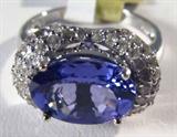 Jewelry 18kt White Gold Tanzanite & Diamond Ring
Fabulous 18kt white gold Tanzanite and Diamond ring, size: 7.
Included AIG Pre-Sale Estimated Retail & Gemological report reads: "One electronically tested 18kt white gold ladies cast Tanzanite and diamond ring. Condition is new, good workmanship. The featured Tanzanite is set within a diamond bezel, completed by a two millimeter wide band. Identified with markings of "18k". Containing:
One prong set oval mixed cut natural Tanzanite, measuring 11.00 x 7.85 x 5.20mm, approximate weight of 3.33ct., clarity is eye clean, type 1, medium dark, very slightly grayish, bluish violet color, (GIA bV 6/3) to medium, very slightly grayish, purple, (GIA P 5/3), cut is good. Transmitting light with no distortion, transparent. The stone displays 40% extinction. Graded in the setting.
Tanzanite is a very rare gemstone that is only found in the country of Tanzania. Originally discovered in 1967. Tiffany & Company named the stone Tanzanite. It is found i