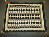 Old Navajo Natural Wool Eyedazzler Indian Rug
Native American Indian hand woven rug, attached tag reads: "By Navajo weaver Mary Spencer". Brown, gray, black, and creamy white diamond patterns. Measures 39" x 52". Appears to be in very good condition.
Z14