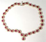 Jewelry 14K Yellow Gold Ruby Diamond Necklace AIG
Sensational 14KT yellow gold, ruby & diamond necklace. Included American International Gemologists (AIG) Pre-Sale Gemological Report reads:
"One electronically tested 14KT yellow gold ladies cast & assembled ruby and diamond necklace. A flexible ribbon of thirty-one ruby and diamond clusters in a contiguous chevron inspired design. Seventeen inch wearable length terminating in a concealed clasp with safety. Bright polish finish, with milgrain detailing throughout. Identified with markings of "14K". Condition is new, good workmanship. Containing:
Thirty-one prong set pear mixed cut natural rubies, measuring an average of 8.00 x 6.00mm, approximate total weight of 32.21 ct., clarity is heavily included, type II, medium dark, moderately strong, slightly purplish red color (GIA slpR 6/4), cut is good. 
Transmitting light with some distortion, transparent to translucent. Naturally occurring internal and external characteristics are present. 