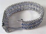 Jewelry Silver Blue & Colorless Sapphire Bracelet
Exquisite silver & sapphire lady's bracelet. Included Gemological Laboratory of America (GLA) Premium Appraisal reads:
"One lady's polished and electronically tested solid silver bracelet mounted with 104 Genuine Blue Sapphire (Corundum)s and Genuine Colorless Sapphire (Corundum)s. This item weighs 35.93 grams & measures 7.10 inches in length and 25.05 mm in width, tapering to 19.89 mm. This bracelet has been finished with a double slip in groove closure. The condition is BRAND NEW. The gemstones have been analyzed in the mounting. 
MAIN GEMSTONES
Identity: Genuine Blue Sapphire (Corundum)
Shape: Oval (Faceted)
Measurements: 4.90 x 3.10 x 2.20 mm
Quantity: 104
Carat Weight: 30.54 (estimate)
Clarity Type: II - may include eye-visible features
Hue: Ceylon Blue
Transparency: Transparent
Tone: Light-Medium (overall)
Quality: 8 - Very Good to Excellent
ADJACENT GEMSTONE
Identity: Genuine Colorless Sapphire (Corundum)
Shape: Round (Faceted)
M