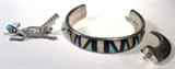 Jewelry Lot of 3 Sterling Silver Bracelet Pin+
Lot of 3 Southwestern style jewelry pieces:
- Beautiful "Zuni" sterling silver cuff bracelet. Inlaid bluish green & yellow stones, possibly turquoise and mother of pearl, with black inlaid stones, possibly onyx, arranged in a Southwestern design. Marked / signed "C-R Zuni", consignor states it is sterling silver. Measures 4.75" long with 1.5" opening. 
- Adorable roadrunner pin / brooch, features a turquoise stone for the roadrunner's eye, intricate embossed designs throughout the pin. Traditional bar pin clasp in the back, marked / signed "Sterling". 
- Single claw pendant with a sterling silver anchor, consignor states that the claw is genuine and the anchor is sterling silver. 
Total weight: 0.86 ozt
ZB1709