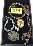 Jewelry Mixed Lot Costume Necklace NRA Belt Buckle
Mixed lot of fabulous costume jewelry -- something here for every occasion!
- NRA "Golden Eagles" belt buckle, cast metal, possibly brass, black enameling for the background with an embossed flying eagle in the center of the buckle. Marked / stamped "Made in U.S.A. 950911". Measures 2.5" x 3".
- Chunky brown beaded necklace with a large gold colored pendant, several sparkling stones and one marble style brown stone in the center. Appears to be on a wire style chain, holds its shape. Measures 14" long. 
- Beautiful colorful necklace featuring several blue rhinestone / pastes arranged in cluster styles all throughout the necklace. Matching clip on earrings. Necklace measures 16" long. 
- Handsome variety of beads and charms on a chain necklace, varying shades of brown throughout, measures 24" long. 
ZB1709
