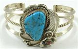 Jewelry Sterling Silver Southwestern Cuff Bracelet
Fabulous sterling silver Southwestern style cuff bracelet featuring a large nugget style turquoise stone, in a saw tooth setting, surrounded by silver floral embellishments, very small red stone, possibly Coral, in the center of one of the silver flowers. Triple split style band, middle split is a rope design. No visible signatures, consignor states this item is sterling silver. Measures 5.25" long with a 1.25" opening. 
Total weight: 1.18 ozt
ZB1341