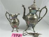 Lot of 3 Silver Plate Simpson Hall Miller Co.
This lot contains three Victorian style silver plated items as follows:
- A treble silver plate coffee urn with an ornate bird theme made by Simpson Hall Miller Co. The spout features a unique duck or swan shape. The lid is missing the pin from the hinge. Measures 11.5" tall.
- A treble silver plate cream pitcher with an ornate bird theme design. Made by the Simpson Hall Miller Co. Measures 7.25" tall.
- An ornately decorated candle snuffer which appears to be silverplate. The snuffer has scissor like handles and a pointed end. There are no manufacturer markings on this item. Measures 7.25" long. The snuffer is missing one of the foot stands and there is a break in one of the scissor hands.
ZB5022