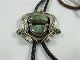 Jewelry Bolo / Bola Tie +Sterling Turquoise Slide
Wonderful bolo / bola tie, featuring a sterling silver slide with two smooth green stones, possibly turquoise, surrounded by leaf style embellishments. Black bolo / bola tie cord, silver tips. This lot also comes with a brown bolo / bola cord. Marked / signed "Bennet Pat. Pend." Consignor states this item is sterling silver.
Total weight: 1.10 ozt
ZB989