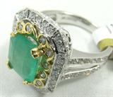 Gorgeous 14KT white & yellow gold emerald & diamond ring, size 7.25. Included AIG Pre-Sale Gemological Report reads:
"One electronically tested 14KT white gold ladies cast emerald and diamond ring. Condition is new, good workmanship. The featured emerald is set within an elaborate two tiered diamond lattice gallery supported by diamond set split shoulders and completed by a 3 millimeter wide band. Bright polish finish, with yellow gold accents. Trademark is ORIANNE. Identified with markings of '14K RT'. Containing:
One prong rectangular step cut natural emerald, measuring 9.00 x 8.35 x 5.90mm, approximate weight of 2.75ct., clarity is heavily included, type III, medium dark, very slightly grayish, very slightly bluish green color, (GIA vslbG 6/3), cut is good. transmitting light with a minimum of distortion, transparent. Naturally occurring internal & external characteristics are present. Indications of oil & opticon residue. Graded in the setting.
Ninety-two bead and bezel set round b