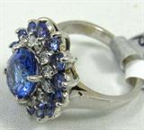 Sensational 14KT white gold Tanzanite & diamond ring, size 5.25. Included American International Gemologists (AIG) Pre-Sale Estimated Retail & Gemological Report reads:
" One electronically tested 14KT white gold ladies cast Tanzanite and diamond ring with a bright polish finish. The ring features an oval tanzanite supported by a tiered cluster of prong set diamonds and tanzanites, completed by a two millimeter wide band. Identified with markings of "14K". Condition is new, good workmanship. Containing:
One prong set oval mixed cut natural Tanzanite, measuring 8.65 x 6.55 x 4.40mm, approximate weight of 1.70ct., clarity is eye clean, type I, medium, very slightly grayish, bluish violet color (GIA vB 5/3) to light, very slightly grayish, violet,(GIA V 5/3), cut is very good. Transmitting light with no distortion, transparent. Graded in the setting.
Fourteen prong set round cut natural tanzanites, measuing 2.50-2.30 x 1.56 mm, approximate total weight of 0.90ct., clarity is eye clean, ty