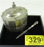 Lot of 2 Sterling Nail File & Silver Plated Box
This lot of vintage items includes:
- A nail file with a sterling silver handle. The hollow handle features a woman's image with long flowing hair. The file measures 6" long. The handle is marked with the word "Sterling" and an unidentified hallmark.
- A silverplate trinket box which has been lined with red velvet material. The box has a double row of an etched floral pattern, and is an oval shape with scalloped edges. The box measures 5" tall x 5" in width x 4" in depth. The bottom of the box is marked Godinger Silver, 1991.
Total weight: .84 ozt.