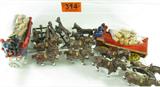 Lot of 2 Cast Iron Horse Drawn Beer Wagon+Drivers
Lot of 2 cast iron toys, including:
- A large, 8 horse drawn beer wagon with two drivers, one Caucasian and one African American driver. 8 horses are brown with white details, wagon is red and blue with white wheels, contains 27 miniature wooden beer barrels. Drivers both detach. Unit appears to be in fair condition, possibly a reproduction, some places where the paint appears to be chipping. Unit measures 30.5" long x 6.25" tall including drivers.
- A smaller 6 horse drawn beer wagon with two drivers, both Caucasian, with 27 miniature wooden barrels. Horses are deep brown with black details. Red wagon with gold details. Drivers both detach. Appears to be in good condition, possibly a reproduction. One of the chains on the horse carriage appears to be missing. Measures 31.5" long x 6" tall including drivers.