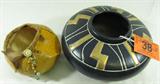 Lot of 2 Gourd Basket & Harris Pottery Bowl
This lot contains the following items:
- A gorgeous piece of pottery from Harris Pottery, Chicago, IL. The black bowl has gold geometric designs around the top. Base has a small chip which is barely noticeable when bowl is displayed. Measures 5.25" tall with a 11" diameter.
- A hand crafted gourd bowl which features a woven design and bead decorations on one side. The southwest design appears to be Native American Indian. Measures 4" tall with a 6" diameter. Signed and numbered on the bottom, "Eileen - 659".