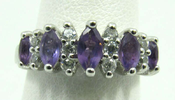 Beautiful sterling silver fashion ring featuring five prong set, marquis shaped, purple colored gemstones and clear stones. Marked "925", ring size: 6.25. Total weight: .11 ozt.
To complete your set see lot #121