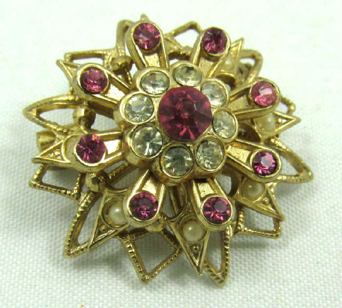 Lovely vintage Coro brooch decorated with faux pearls and clear and pink colored rhinestones. Marked "Coro", measures: 1" diameter.

ZB4148