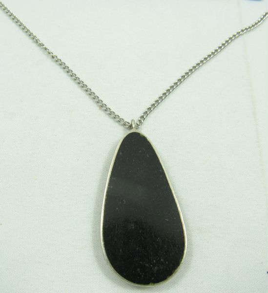 Jewelry Sterling Silver Onyx Pendant & Necklace
Stately sterling silver necklace featuring a large teardrop shaped pendant accented with an onyx stone. Marked "sterling", measures: 18" long. Total weight: .40 ozt.
