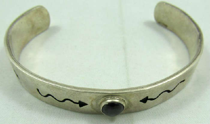 Jewelry Sterling Silver Onyx Cuff Bracelet
Lovely sterling silver cuff bracelet with Southwestern style arrow and heart designs. Bracelet is accented with an oval shaped Onyx stone. Marked / signed "925 P Anny", measures: 5" wide with 1.5" opening. Total weight: .67 ozt.