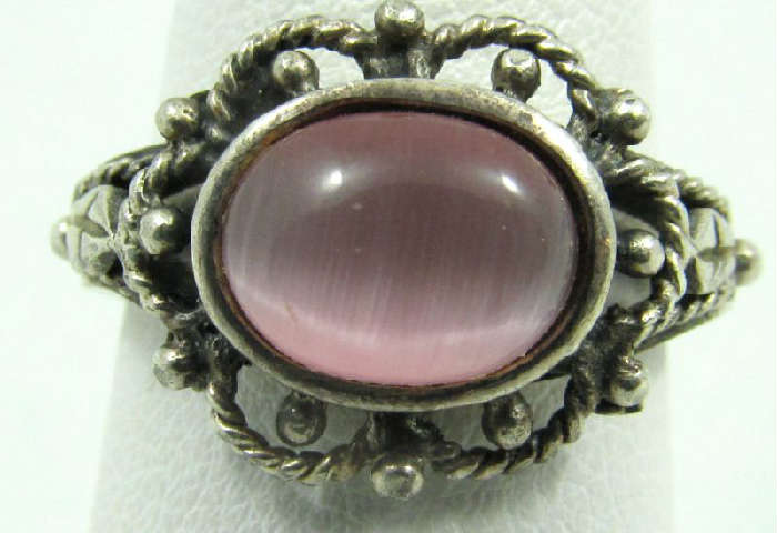 Jewelry Sterling Silver Pink Moonstone Ring
Lovely sterling silver fashion ring featuring an oval shaped pink colored stone, possibly a moonstone. Ring has lovely metalwork design around stone. Marked "925", ring size: 7.5. Total weight: .11 ozt.