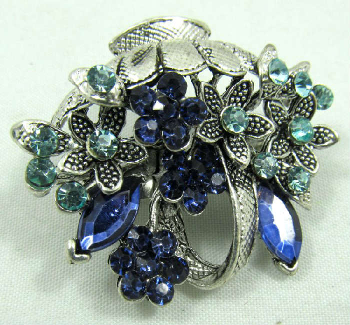 Jewelry Flower Basket Brooch / Pin
Gorgeous silver toned flower basket shaped brooch / pin accented with blue rhinestones. Unknown maker, measures: 1.5" wide.