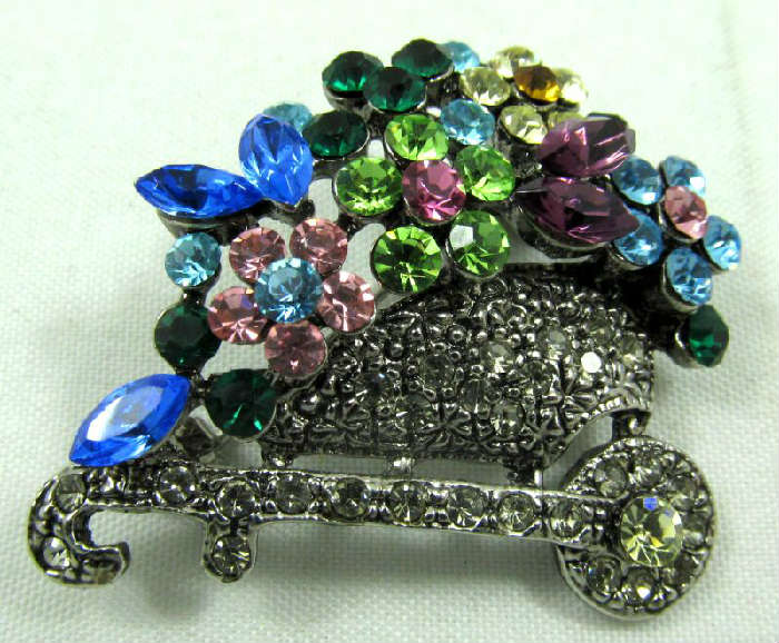 Jewelry Rhinestone Flower Cart Costume Brooch
Gorgeous silver tone costume brooch shaped like a flower cart, accented with colorful rhinestones. Unknown age and maker.