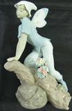 Lot#: 373
Description: Lladro Privilege "Prince of the Elves" Figurine
Fabulous "Prince of the Elves" Lladro Privilege porcelain figurine with intricate detail! This statuette depicts a boy fairy sitting on a branch or rock, piece has delicate flowers. Figurine is marked "Lladro Privilege GU36 U hand made in Spain, Daisa 2000 - #7690”. Figure is in wonderful condition, no signs of chips, cracks or breaks! Original box and sleeve included, but shows some signs of wear and has some writing. Figurine measures: 9" tall x 6.5" wide. Comes from a smoke free home!