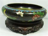 Lot#: 317
Description: Lg Antique Chinese Cloisonné Bowl, Qing (Manchu)
A beautiful original antique Chinese brass and enamel cloisonné bowl from the Qing (Manchu) Dynasty. This fancy Chinese bowl has an Elaborate Archaic Ming mark on the bottom which dates it from 1910-30. Set on a carved Rosewood stand it has bright colors, and intricate "T-fret" detailing with floral motifs on a black background and turquoise bottom. It is in pristine condition with no dents or missing enamel. There is some pinhole size pitting which is normal. Measures 10” in diameter by 3” tall or 5.25” tall on the stand.
From the internet: "The Qianlong reign was the most influential for all the arts in China, including cloisonné. Most experts agree that the late 18th century was the apogee of Chinese cloisonné with its exceptional cloisonné renditions. During the end of the Qing Dynasty era of the 19th century, 1850-1911, smaller decorative items became popular, strongly encouraged by the many shipping trading