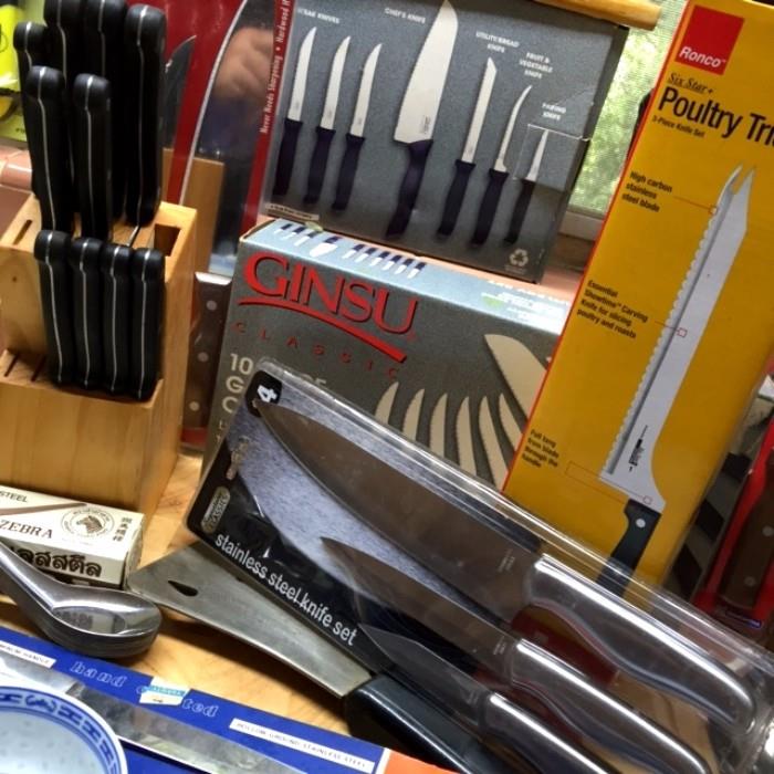 Many sets of knives, some in original packaging.