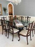 Chippendale style dining table, three tiered bevel glass top, 8 upholstered gold damask chairs.