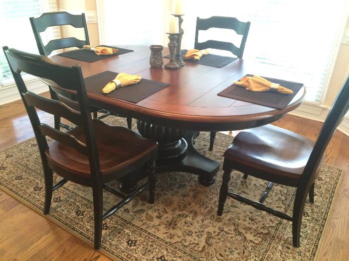 Dining table with black pedestal base and 4 black chairs