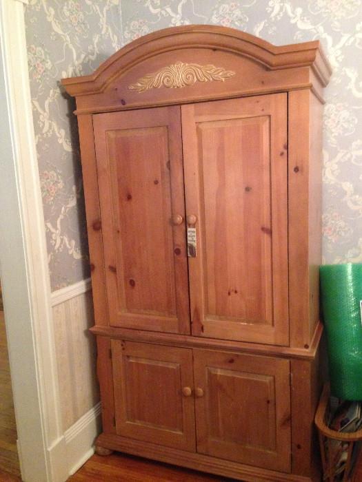 Beautiful armoire designed to hold a 32-inch TV, now used for storage. You could make a nice mini-bar out of it.