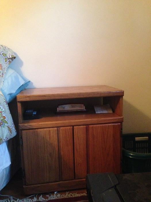 Oak TV stand being used as a nightstand.