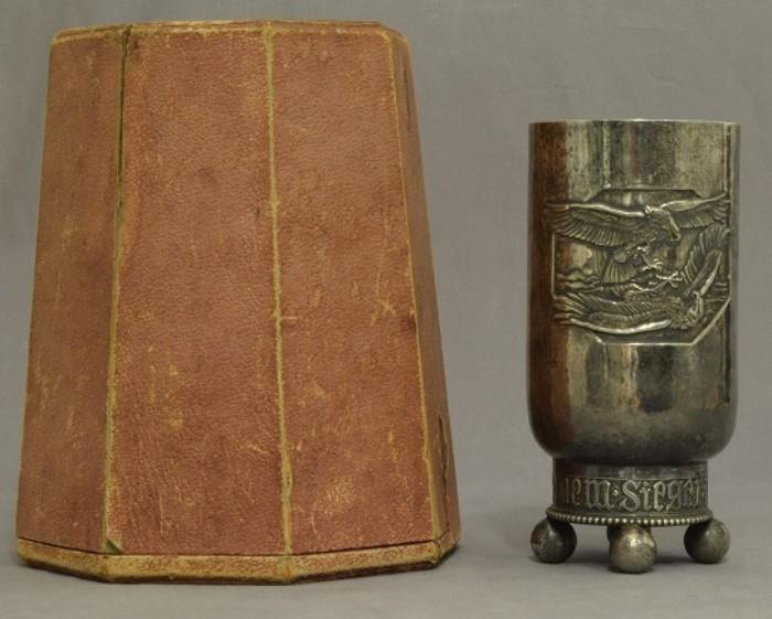 Lot # 62 German WWI Aviator Aerial Kill Honor Goblet Imperial German World War I Aviator Aerial Kill Presentation Engraved Honor Goblet. This silver goblet was awarded to a pilot named 'Ernest Freiherr von Althaus' after achieving his first aerial kill, and is hand engraved to him in Memorium. He was an ace and a Pour Le Merite Blue Max Winner during WWI. The front shows two flying eagles attacking each other. This piece is hand engraved on the back side with all nine of his confirmed aerial kills. It lists the date of the kill, and the type of airplane that he shot down. Measures 7 13/16" tall by 3 13/16" in diameter. The base reads 'Luftkampfr - Dem - Siegerim'. It is marked around the base with a half-moon; King's crown; 800 (Silver content); eagle. The bottom reads “Chef des Feldflugwesens” with an eagle in the center. The goblet is solid hand hammered silver. The interior of the cup portion is gold plated. Includes A brown leatherette carrying case with a brown velvet interior.