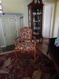 Entry hall rug, one of two chairs, curio cabinet.