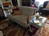 Lovely living room love seat, beautiful wool rug and vintage shabby chic end table with hand painting.