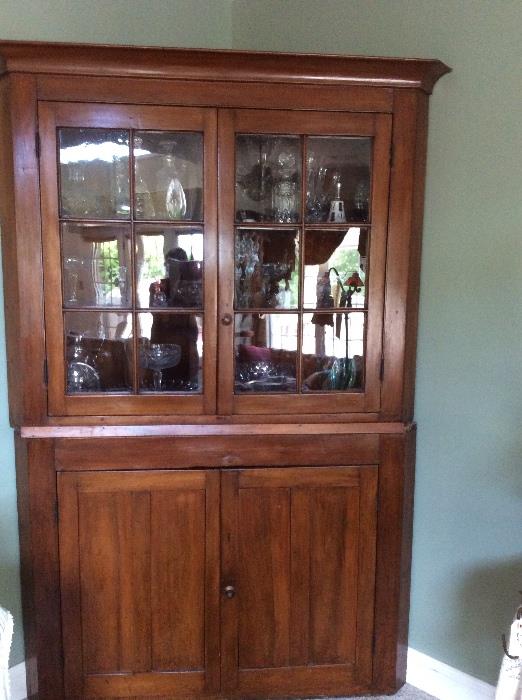 Antique corner cupboard in hardwood - 12 lights up with blind chamfered down.  Original crown. 