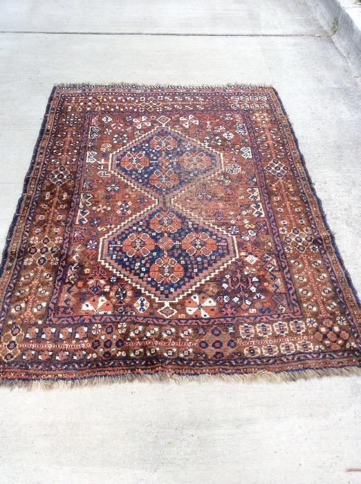 Antique Persian rug in browns and blues with wear to central portion