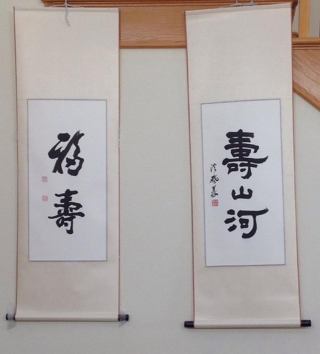 A pair of scrolls, the one on the right roughly translates to , Congratulations  for life, and the one on the left , roughly translates to Lucky and long life!