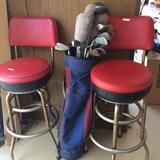    Two red stools; set of golf clubs