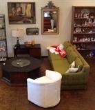 Mid-Century Modern olive green sofa, mid-century octagon coffee table, art, mirror, desk, white barrel chair. 