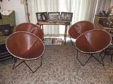 Mid-Century Modern leather saucer chairs on black iron legs