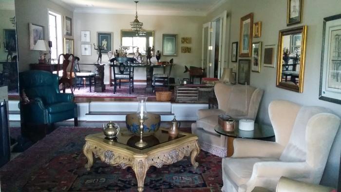 This is a view of the sunken living room, showcasing the Antique Serapi, walls that look like a NY apartment, huge Galle bowl, upholstered armchairs, MCM round wooden table, with 1" thick glass top and a very dated, but comfy leather recliner. 